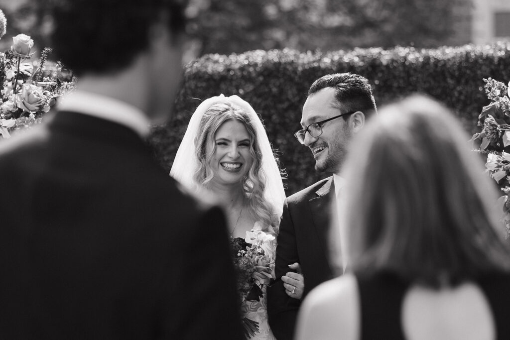 bride and groom smile during their wedding ceremony