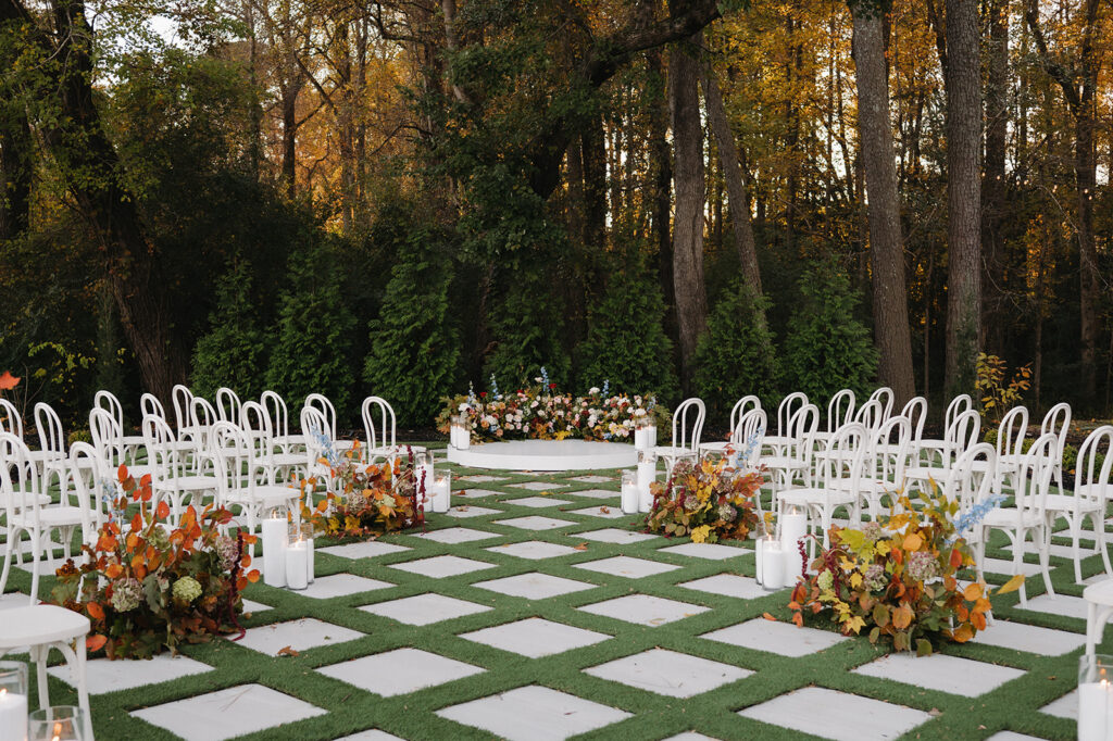 wedding ceremony set up with lots of fall flower arrangements at the greenhouse at arrows farm