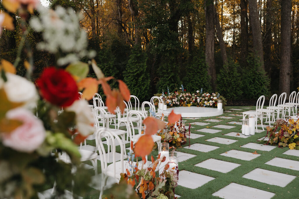 wedding ceremony set up with lots of fall flower arrangements at the greenhouse at arrows farm