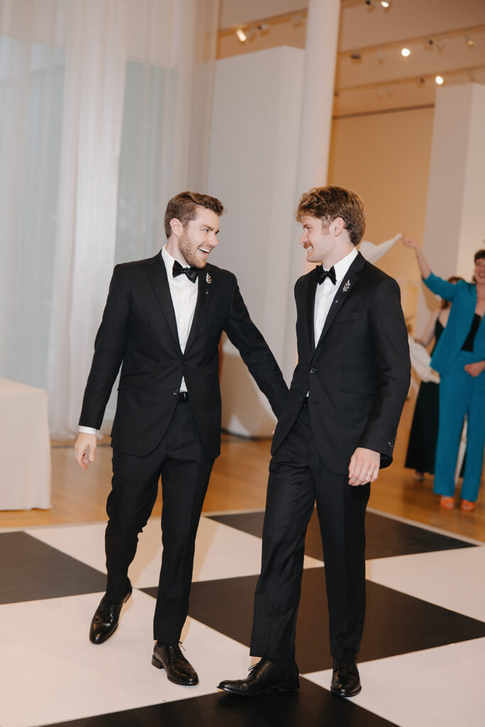 lgbtq couple makes their grand entrance at their wedding at the NCMA raleigh